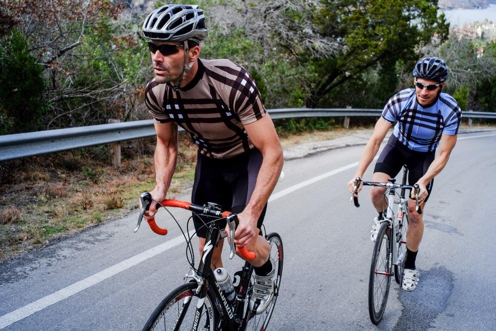 Two Men riding up road on bikes